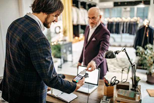 Well dressed man paying suit in store with credit card